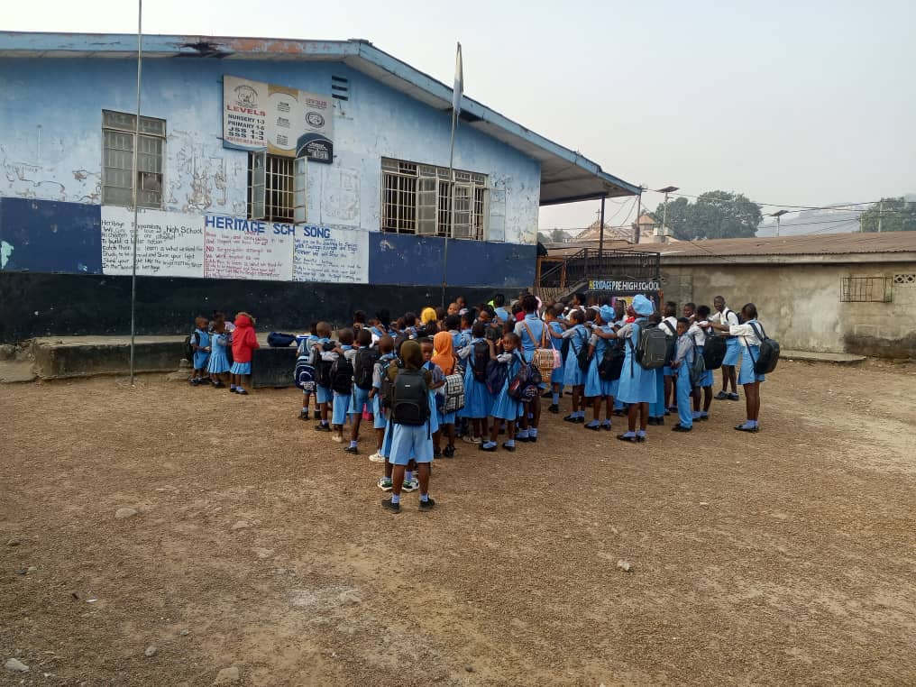 Students gathered together in a schoolyard before class at a partner school